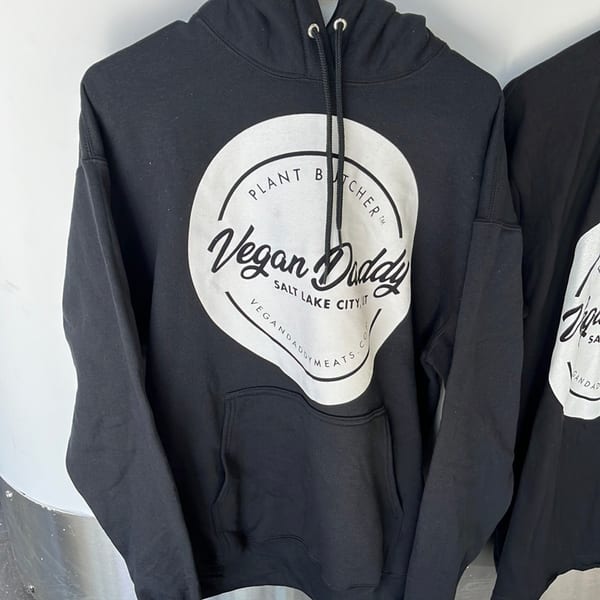 Black Vegan Daddy hoodie with a white circular logo featuring "Plant Butcher" and "Salt Lake City, UT".